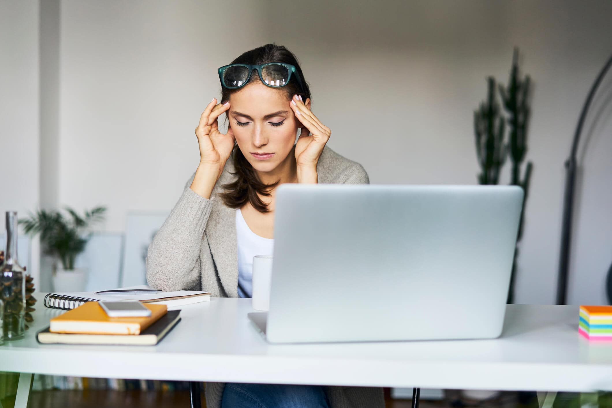 Woman looking frustrated, with computer across from her.